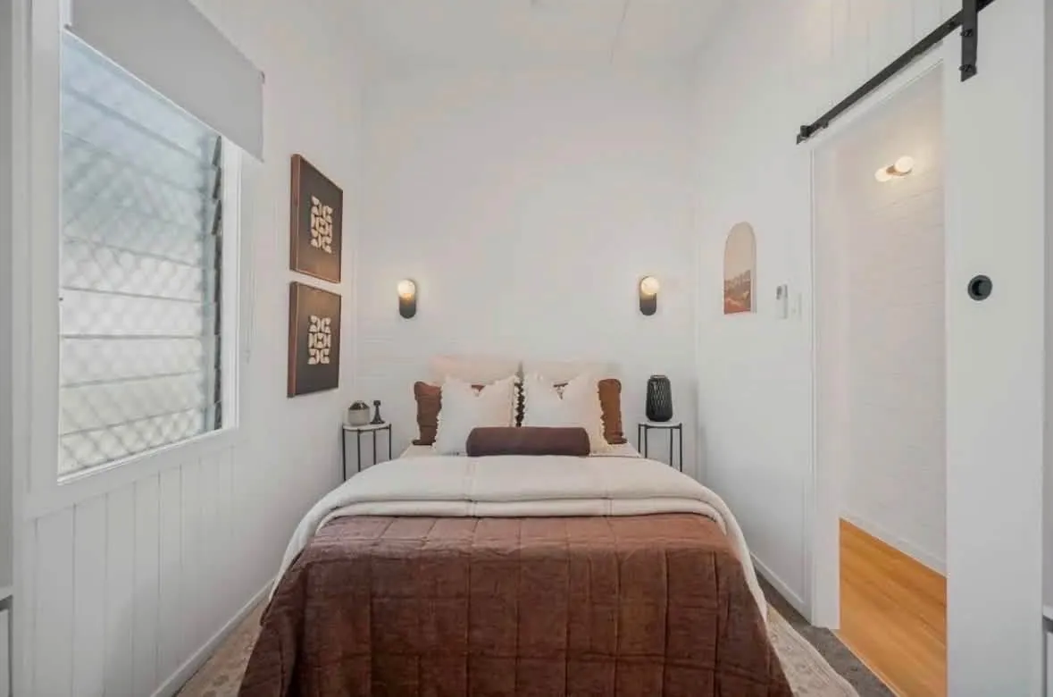 Bedroom project finished view, with paired wall lights above the bed